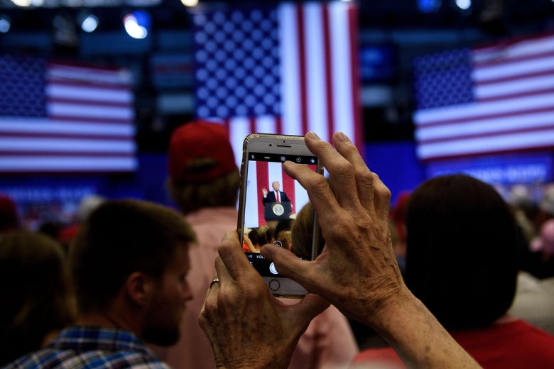 A woman takes a photo as US President Donald Trump speaks during a rally for Rep. Kevin Cramer (R-ND) on June 27, 2018 in Fargo, North Dakota.